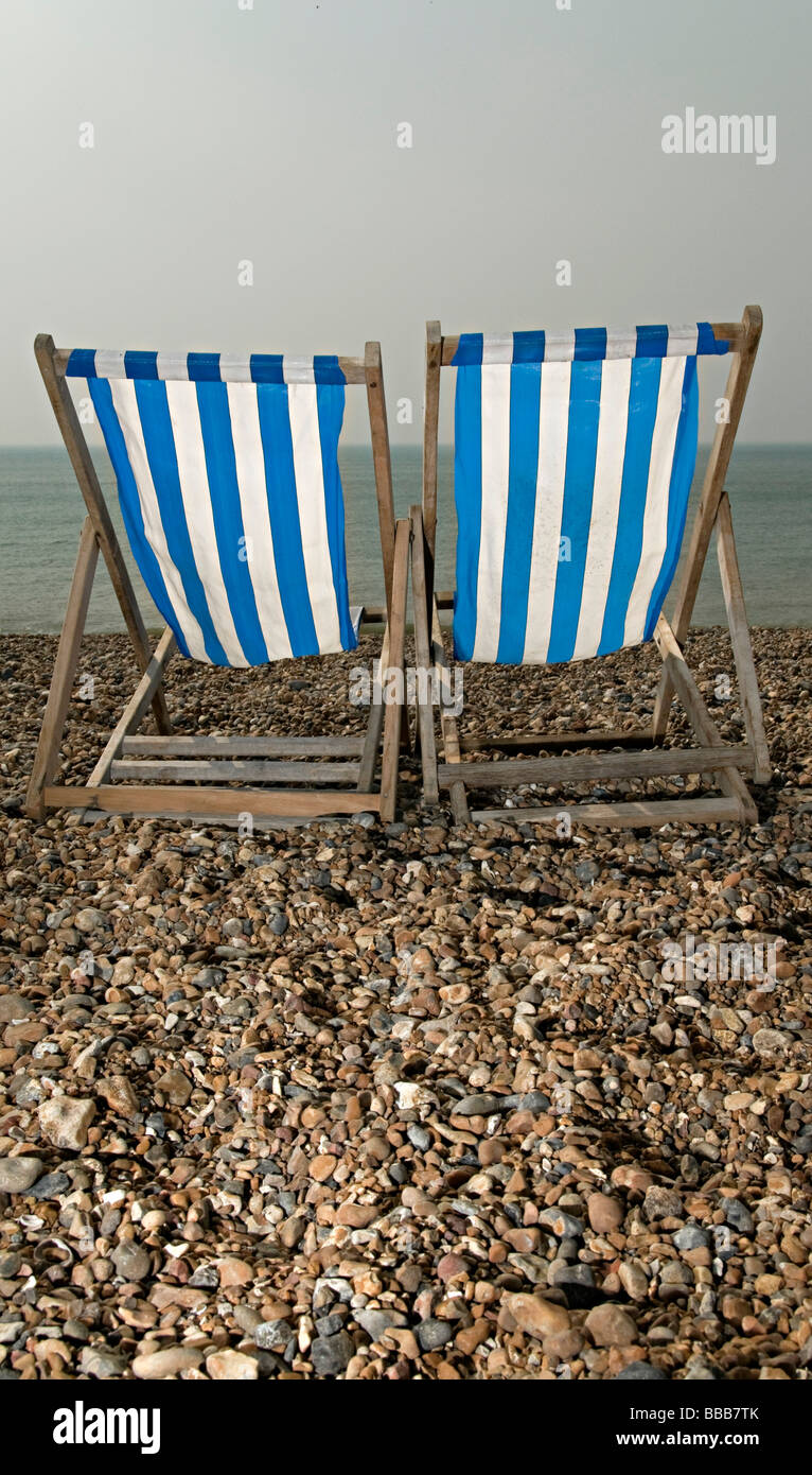 deckchairs on brighton beach while are available to hire so you can sit and sunbathe Stock Photo