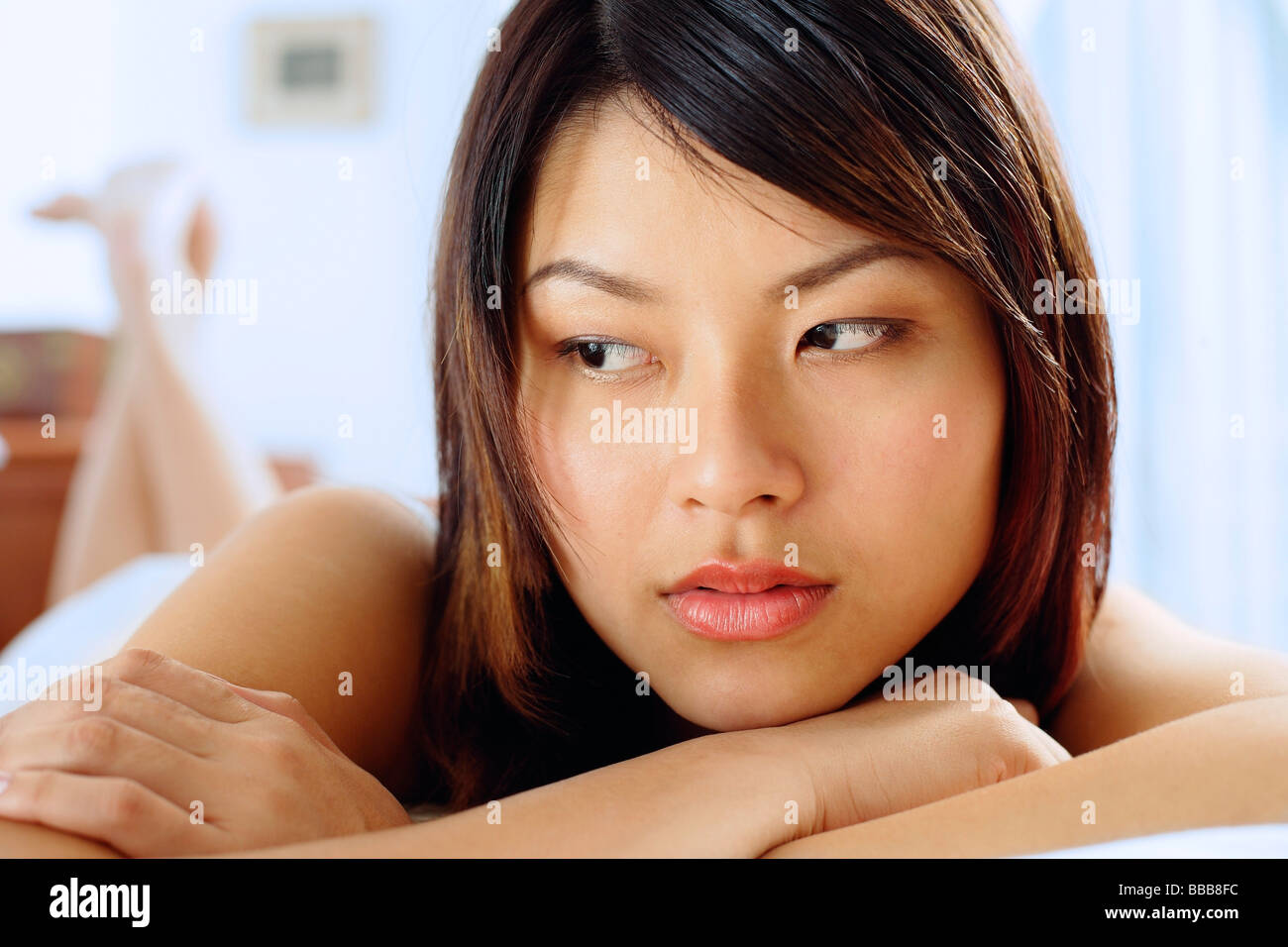 Woman lying on front, arms crossed, looking away Stock Photo Alamy