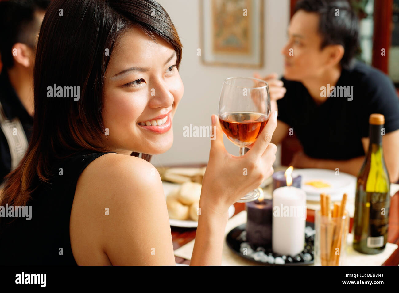 Woman with wine glass, looking away, smiling Stock Photo - Alamy