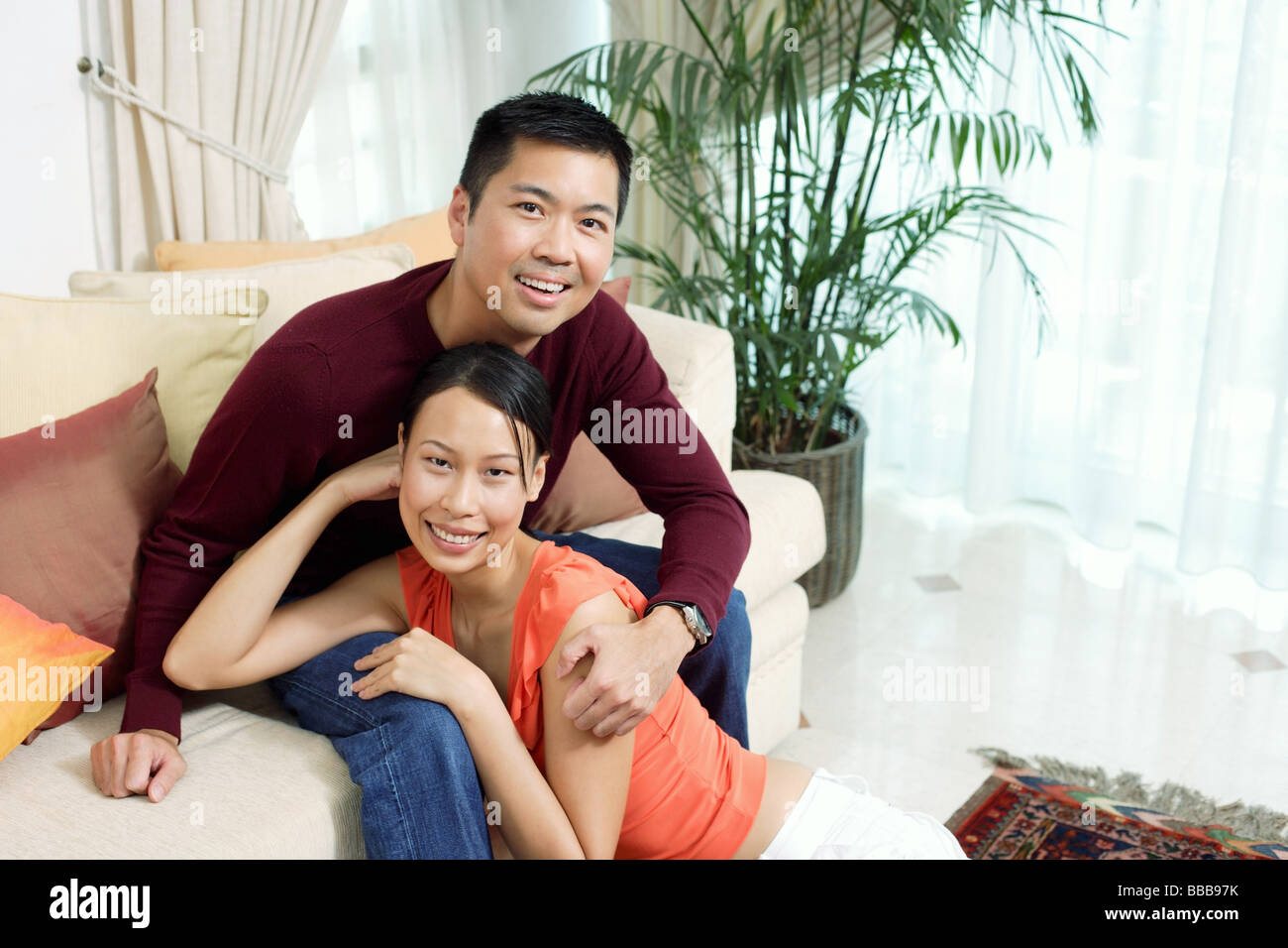 Couple in living room, smiling at camera, portrait Stock Photo - Alamy