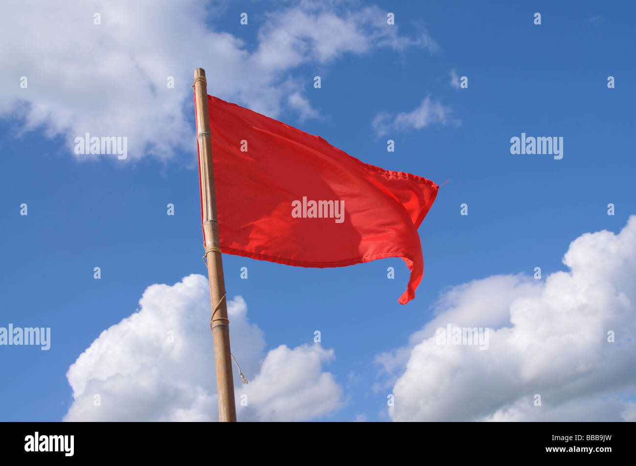 A red flag blowing in the wind. Stock Photo