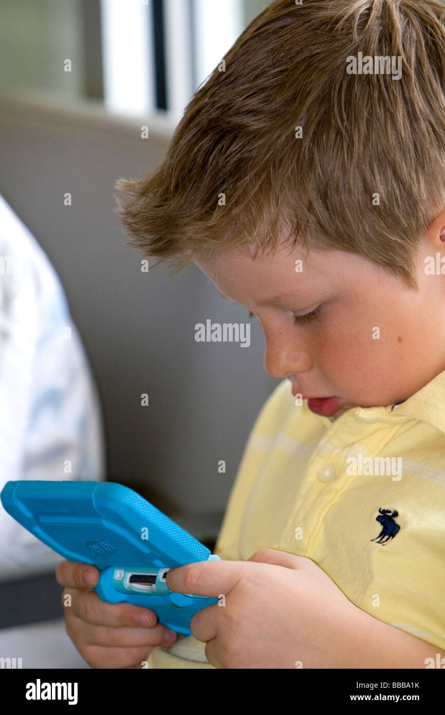 Boy playing with a personal video game system at the Boise Airport Idaho USA MR Stock Photo