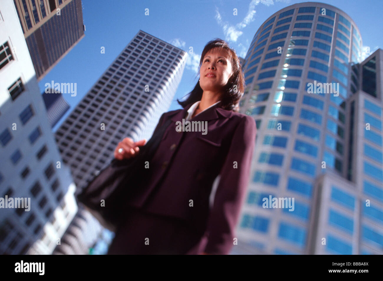 Female executive standing in front of high-rise buildings, low angle view Stock Photo