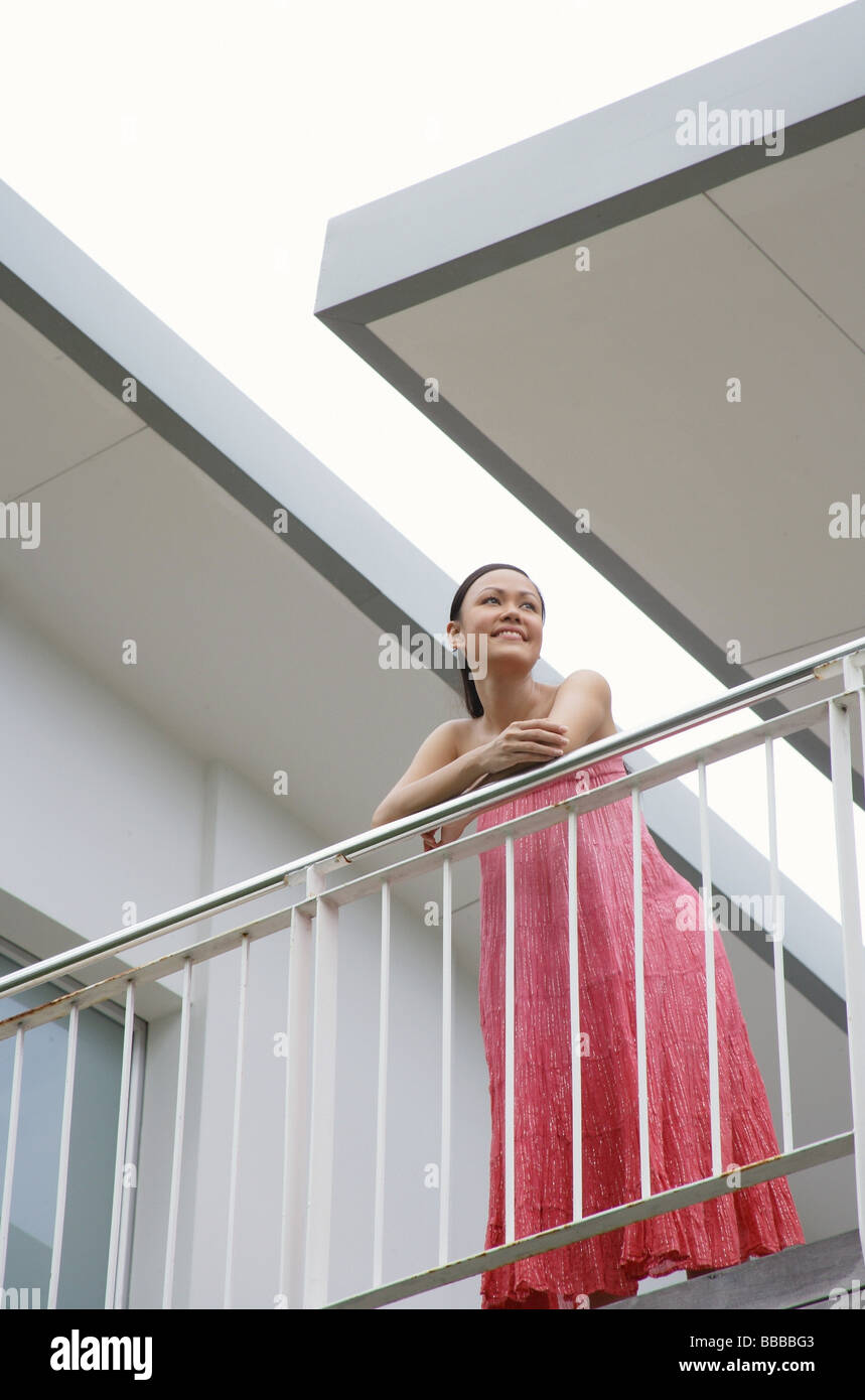 Woman standing on balcony, leaning on railing Stock Photo - Alamy