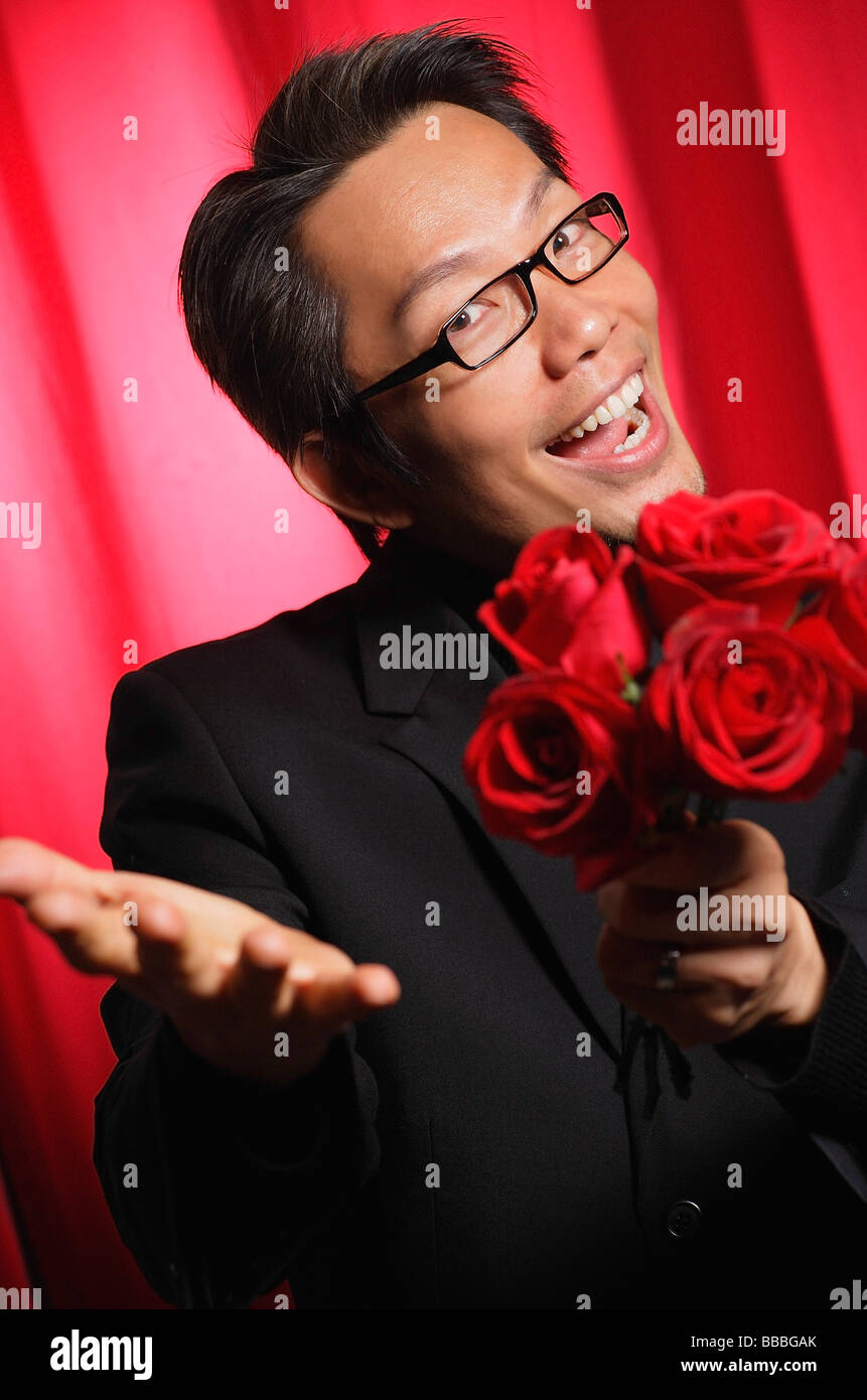 Man holding a bouquet of roses, smiling at camera Stock Photo - Alamy