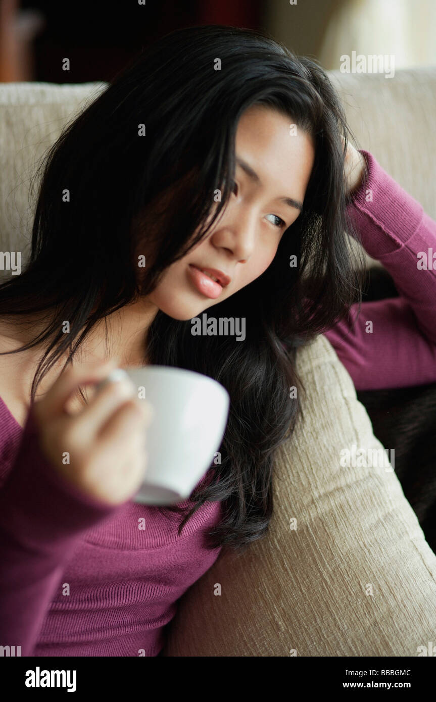 Young woman relaxing with cup of tea Stock Photo - Alamy