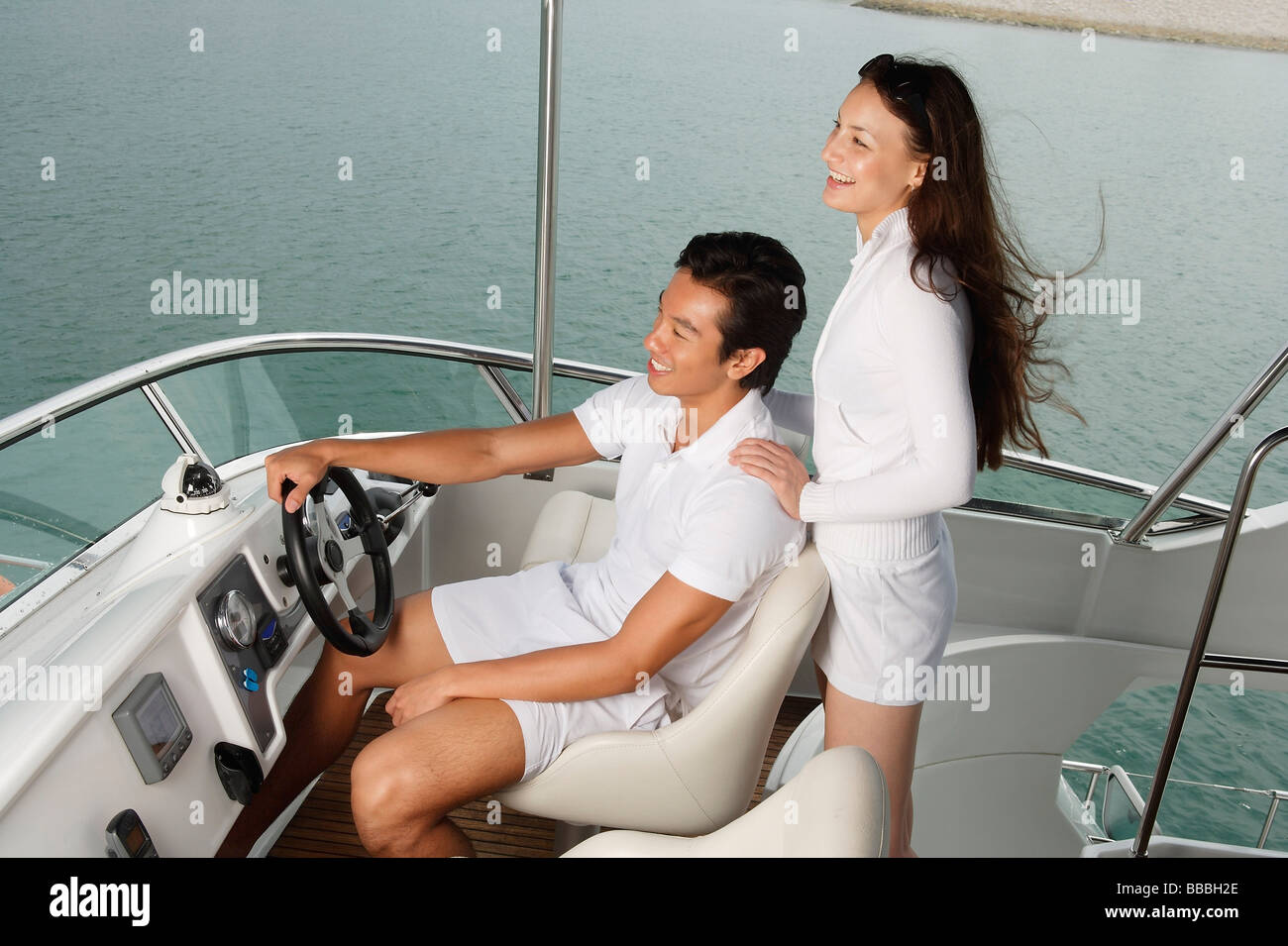 Young couple on yacht, looking into distance Stock Photo
