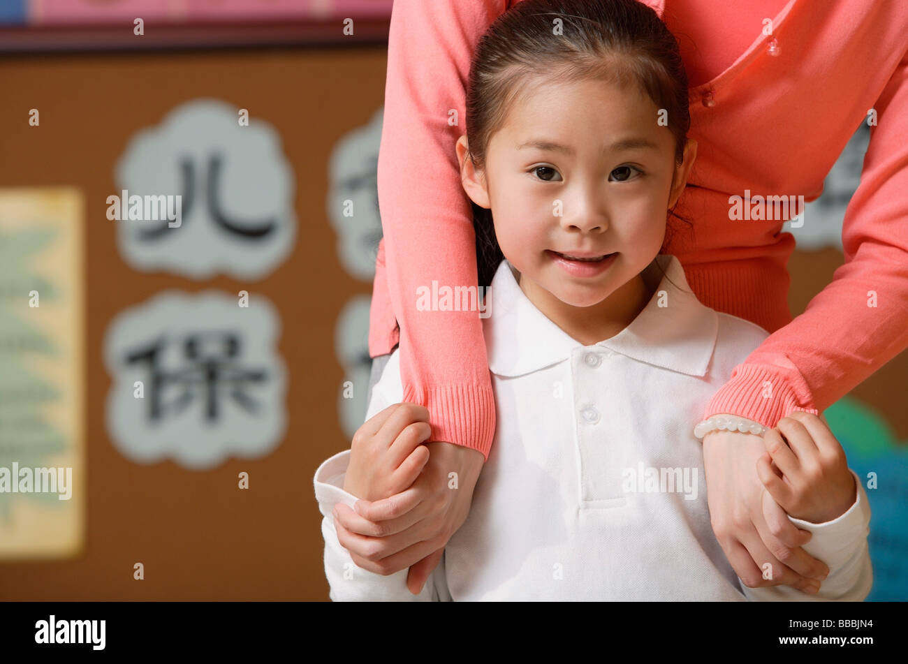 Young schoolgirl smiling at camera with teacher Stock Photo - Alamy