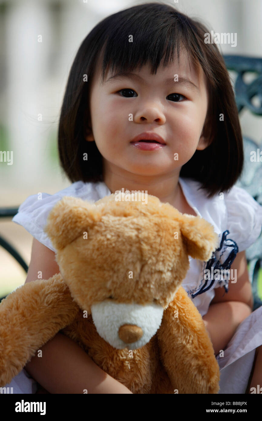 A young girl looking at camera, holding teddy bear Stock Photo - Alamy