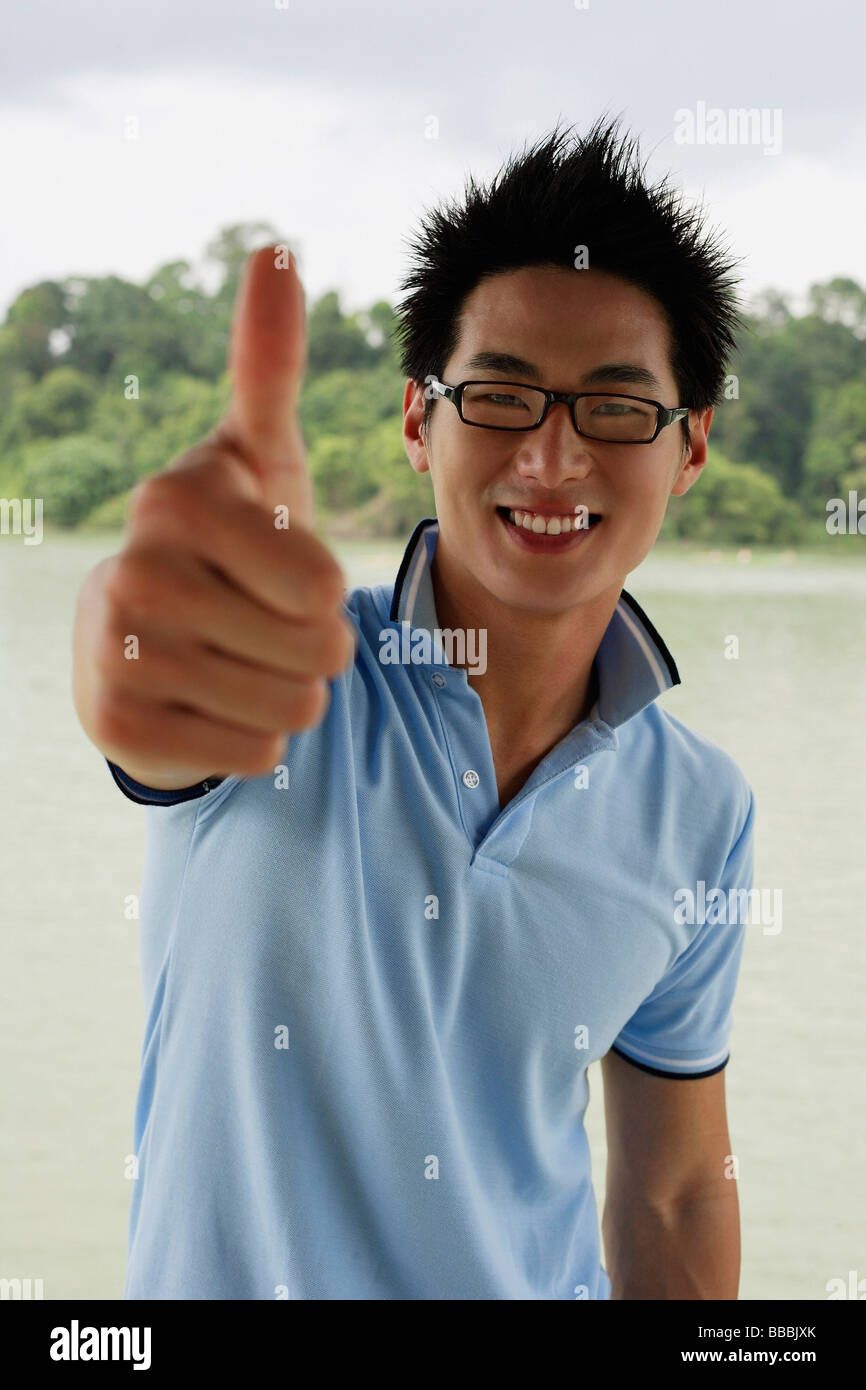 Man in polo shirt and glasses, making a thumbs up sign Stock Photo - Alamy