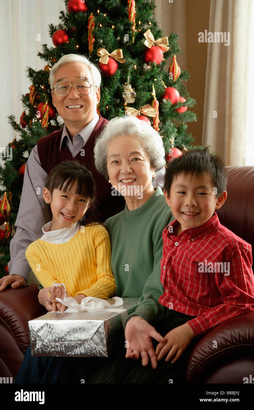 Grandparents with grandchildren at Christmas time smiling at camera