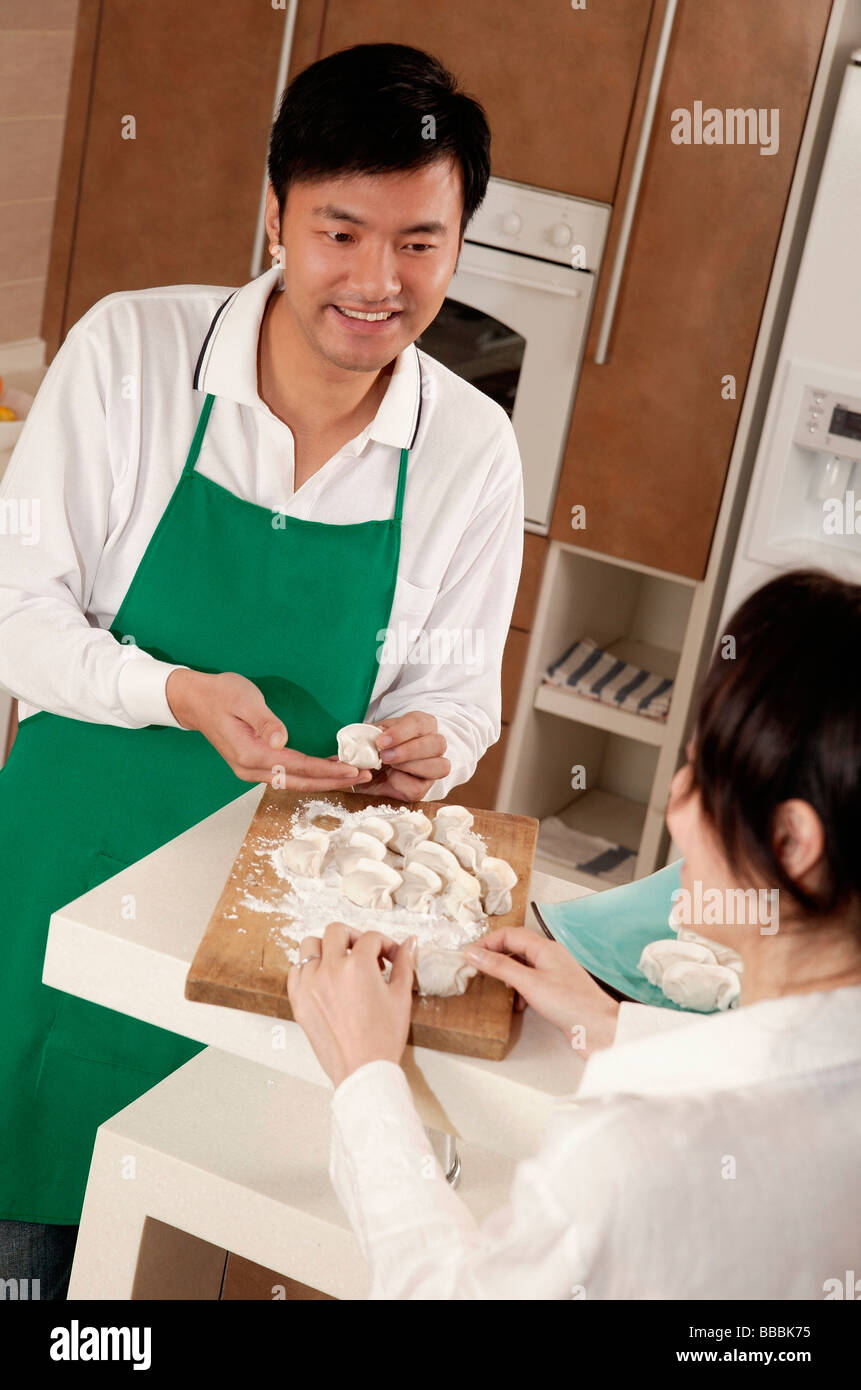 Couple in kitchen kneading dough Stock Photo - Alamy