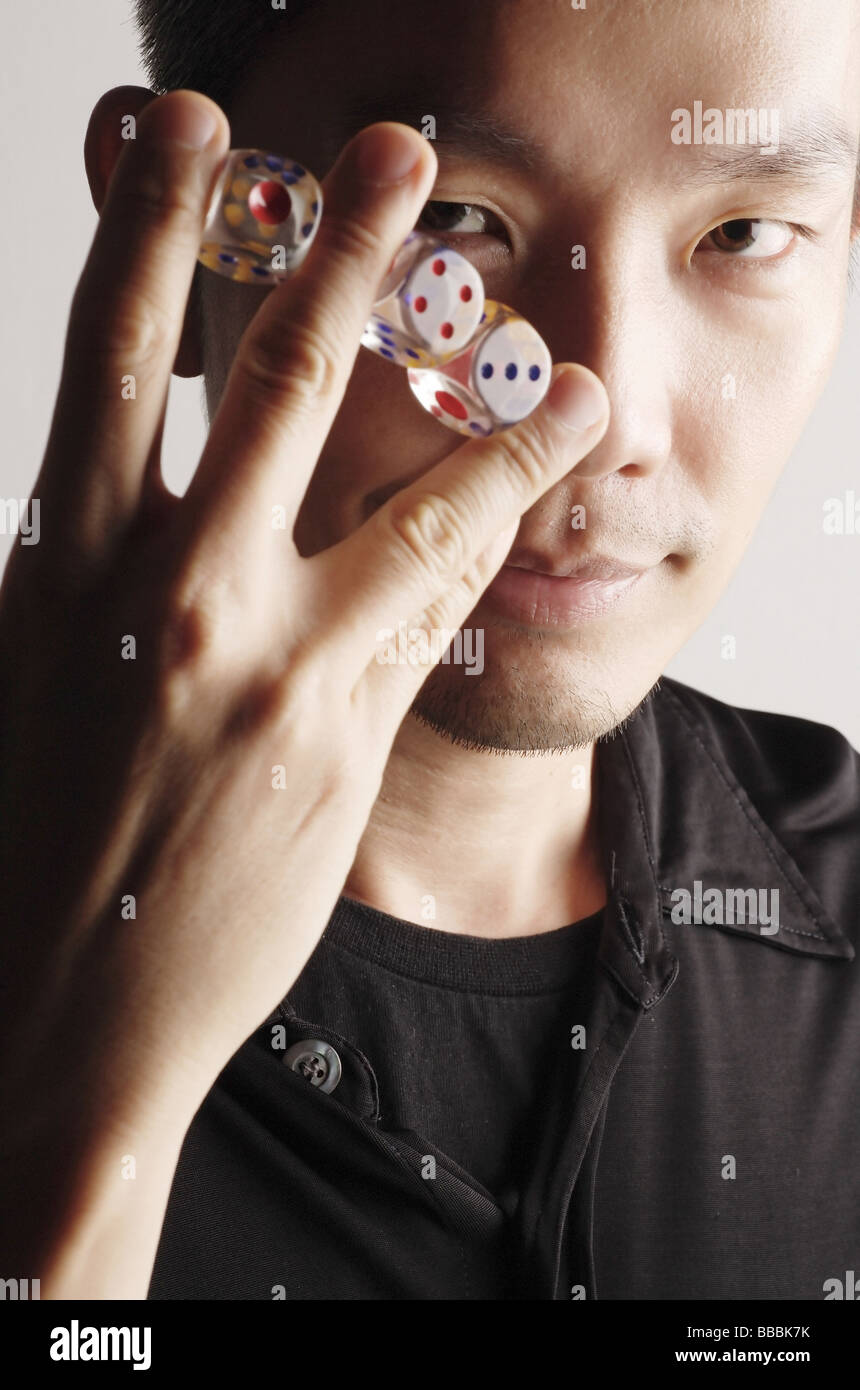 Man holding three dice between fingers Stock Photo Alamy