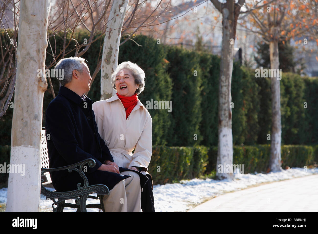 Elderly couple sitting on park bench Stock Photo - Alamy