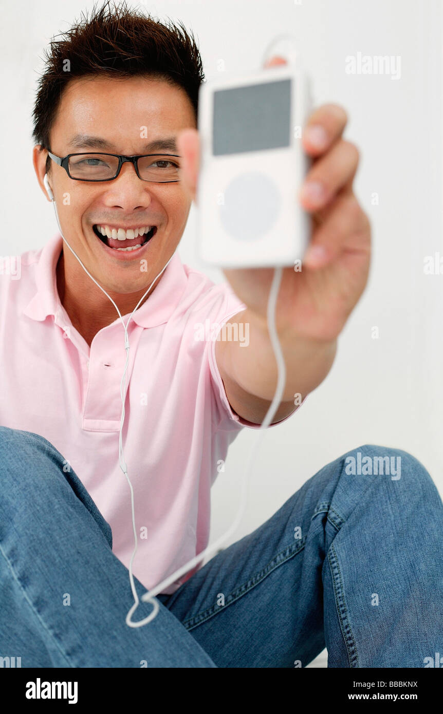 Man holding MP3 player towards camera Stock Photo - Alamy