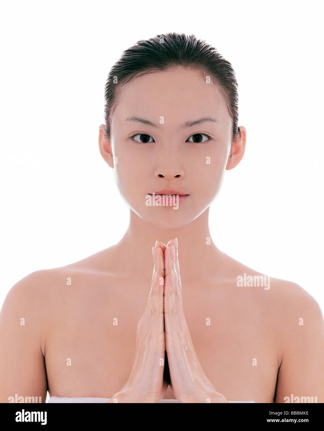 Young woman, hair pulled back, hands together, facing camera Stock ...