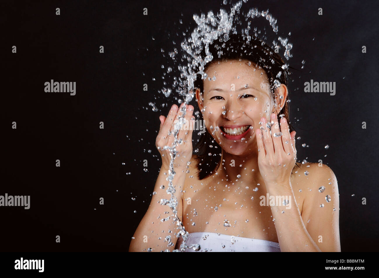 Woman splashing her face with water, smiling Stock Photo - Alamy