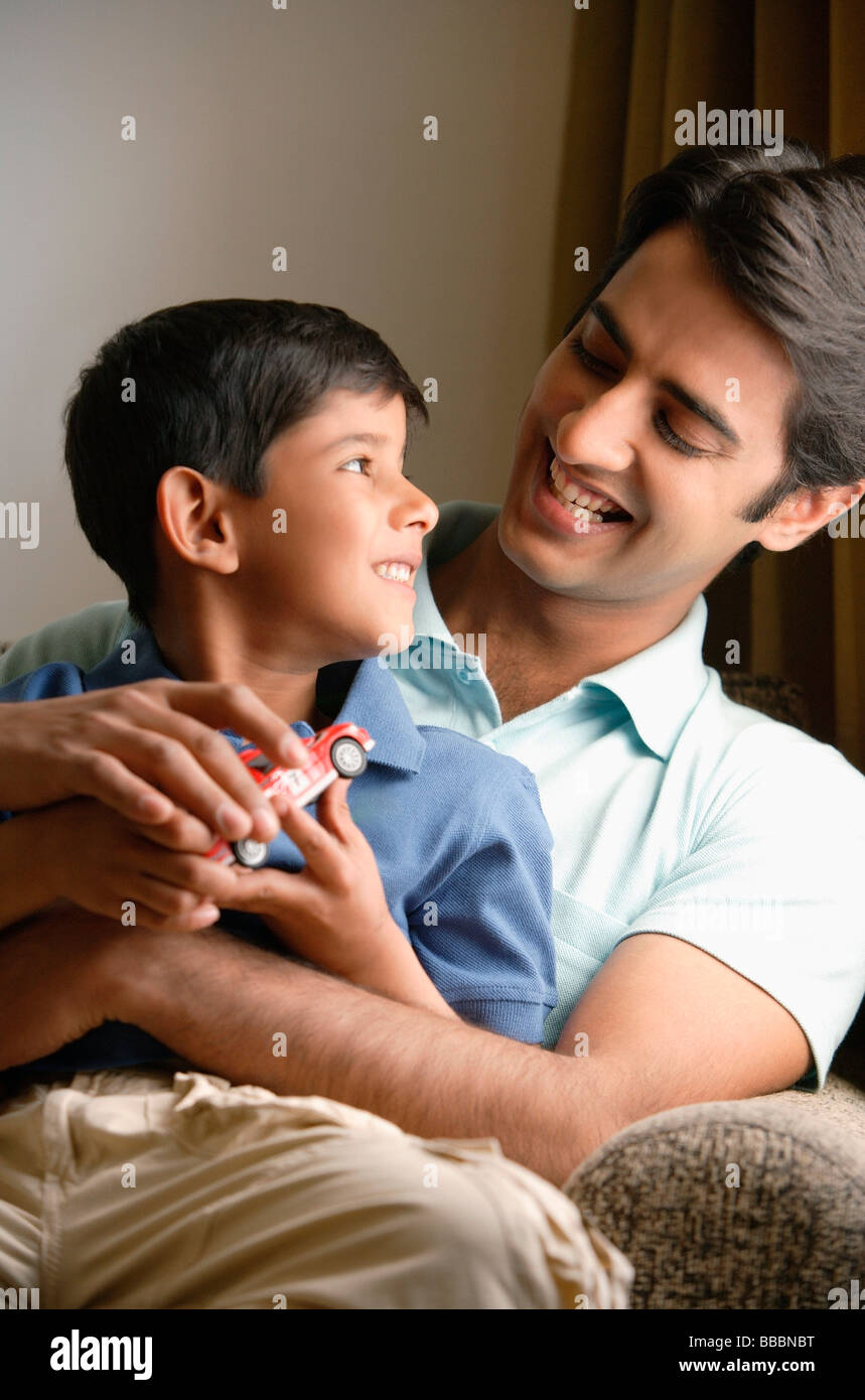 True Father Smiling father and son smile at each other, red truck Stock Photo - Alamy