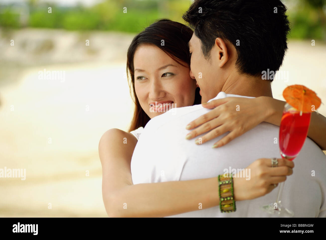 Couple hugging, woman looking away and smiling Stock Photo - Alamy