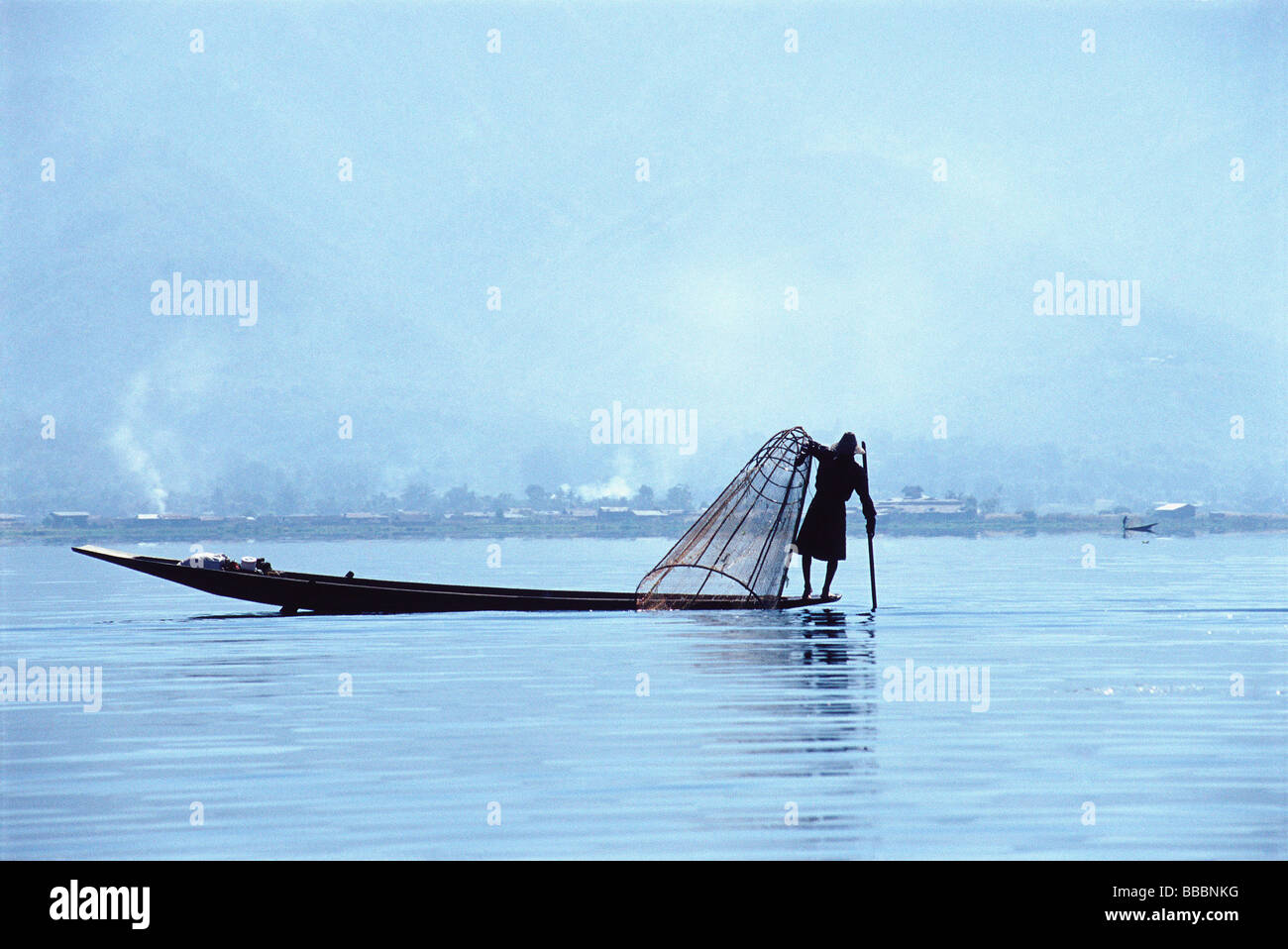 Myanmar (Burma), Inle Lake, silhouette of fisherman in boat on Inie ...