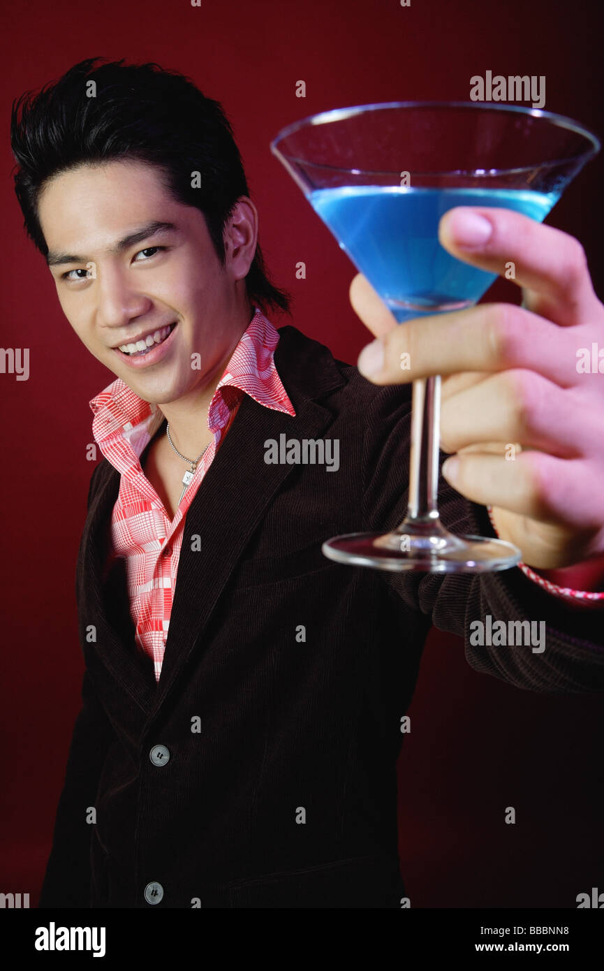 Man holding up cocktail glass Stock Photo - Alamy