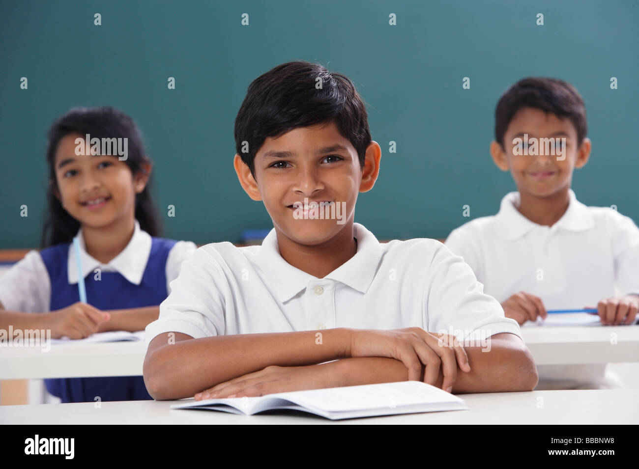 three students smiling at camera, boy in center Stock Photo - Alamy