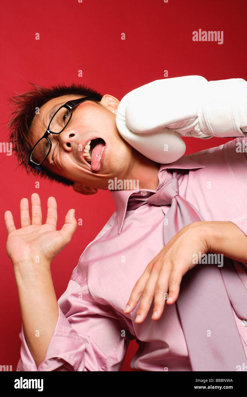 Businessman being punched by boxing glove Stock Photo