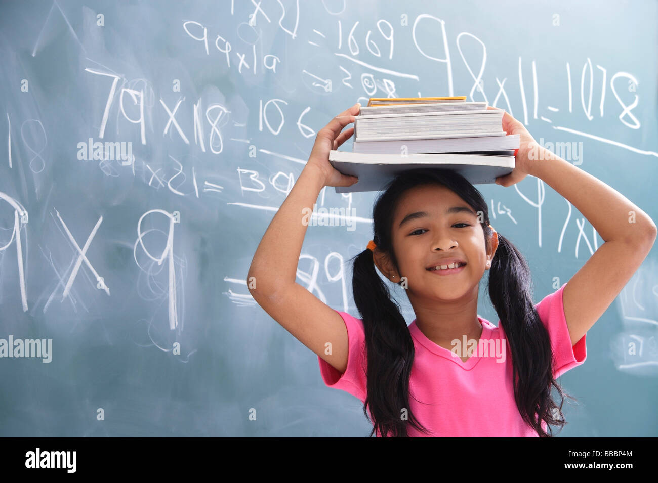 girl with books stacked on head Stock Photo - Alamy