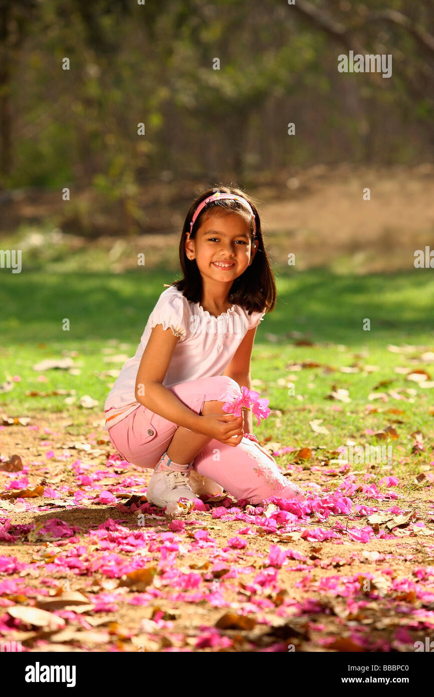 young girl kneeling in park Stock Photo Alamy