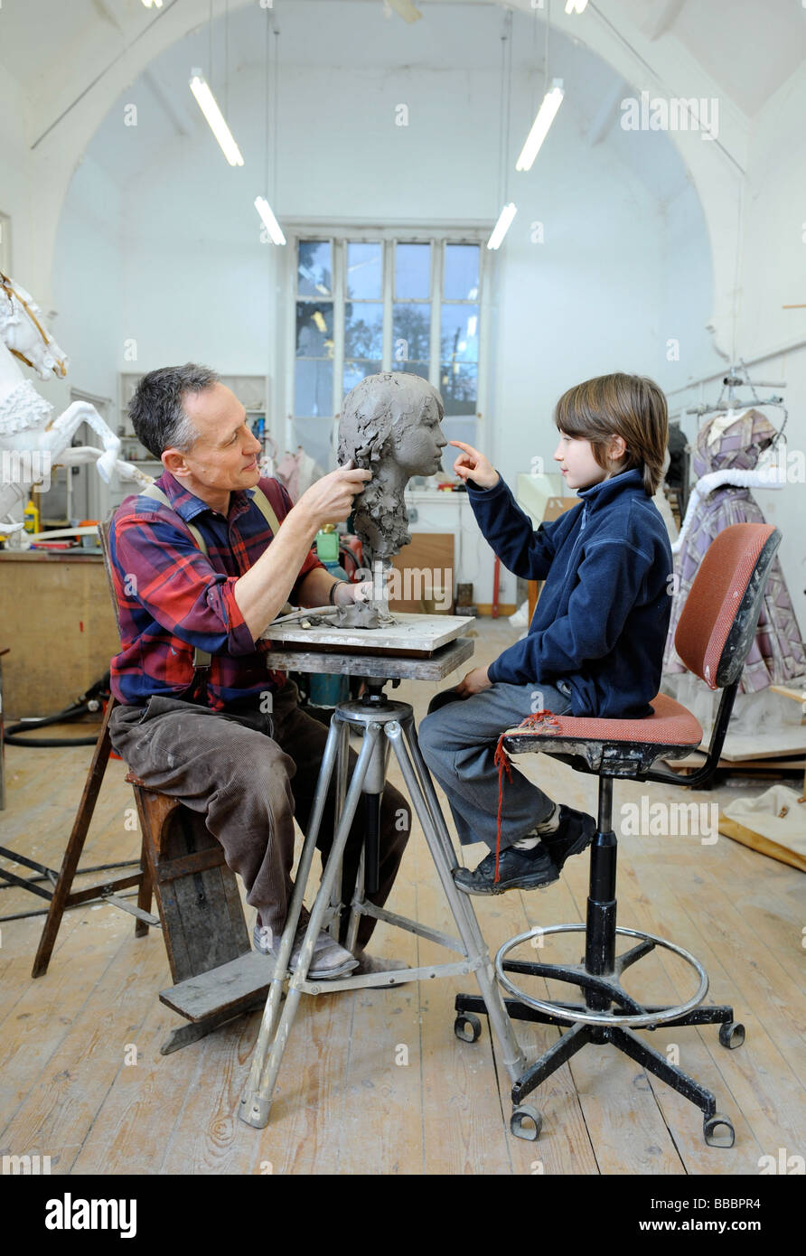 Sculptor Mark Richards in his studio near Ludlow working on a clay head of his son Gil 2008 Stock Photo