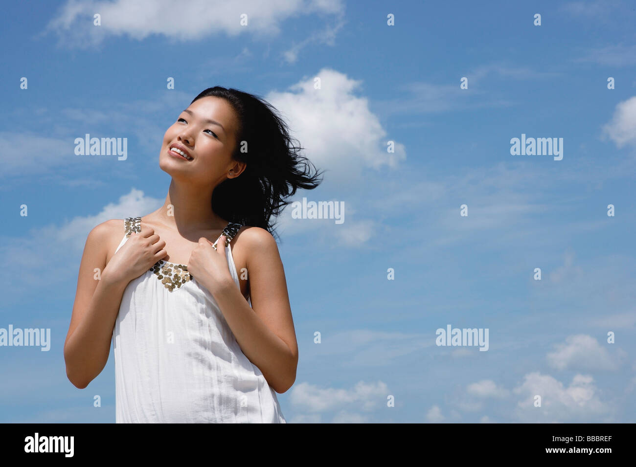 Woman in white top, smiling, looking away Stock Photo - Alamy