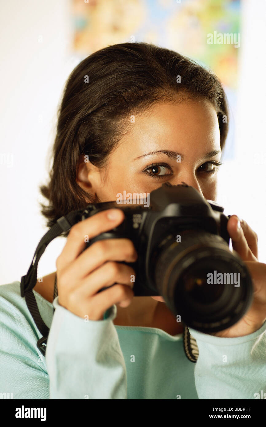 Young woman holding camera in front of her face Stock Photo - Alamy