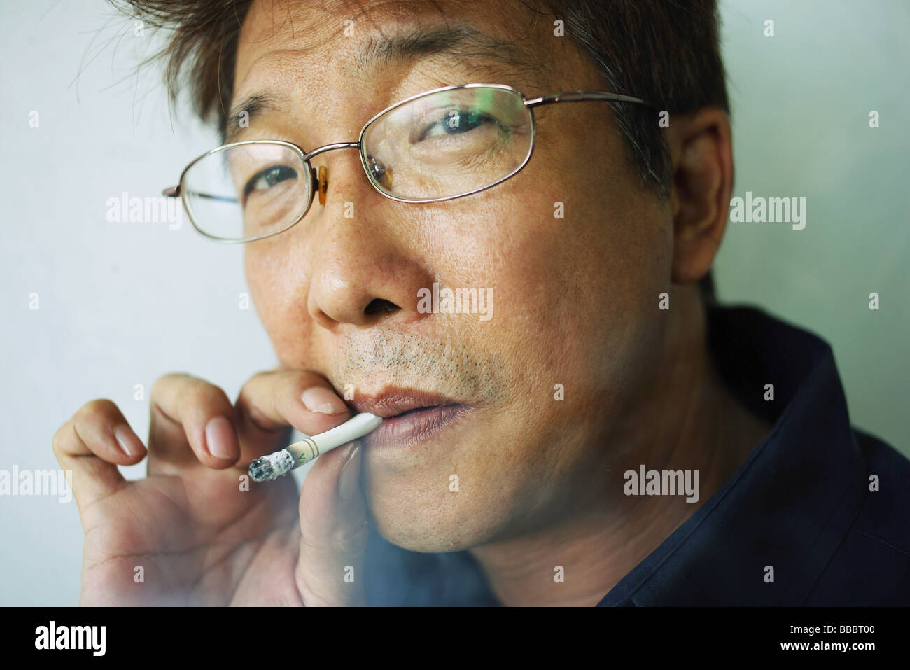 Man smoking cigarette, headshot Stock Photo