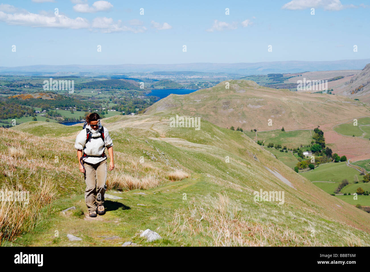Female hiker on footpath that leads to summit of Place fell near Glenridding. Ullswater in the background. The Lake District. Stock Photo