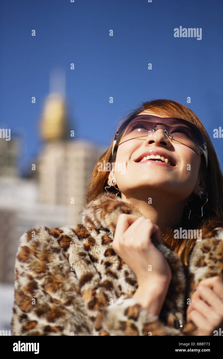 Young woman looking up, wearing sunglasses and fur coat Stock Photo - Alamy