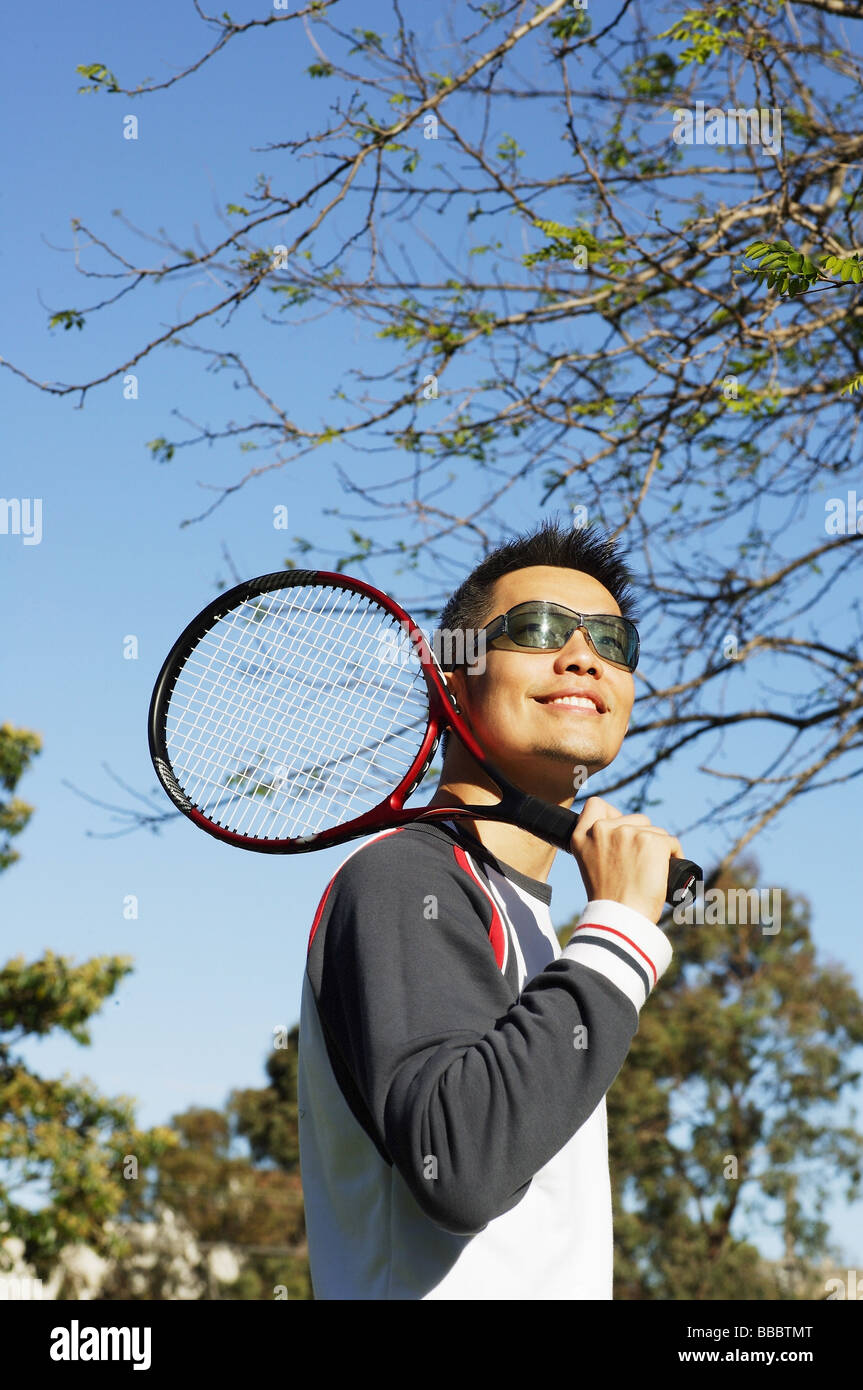 Man holding tennis racket over shoulder Stock Photo Alamy