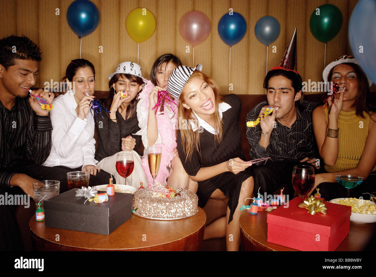 Young adults celebrating birthday, wearing party hats Stock Photo Alamy
