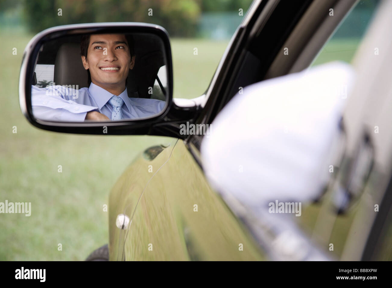 Reflection of smiling man in car rear view mirror Stock Photo - Alamy