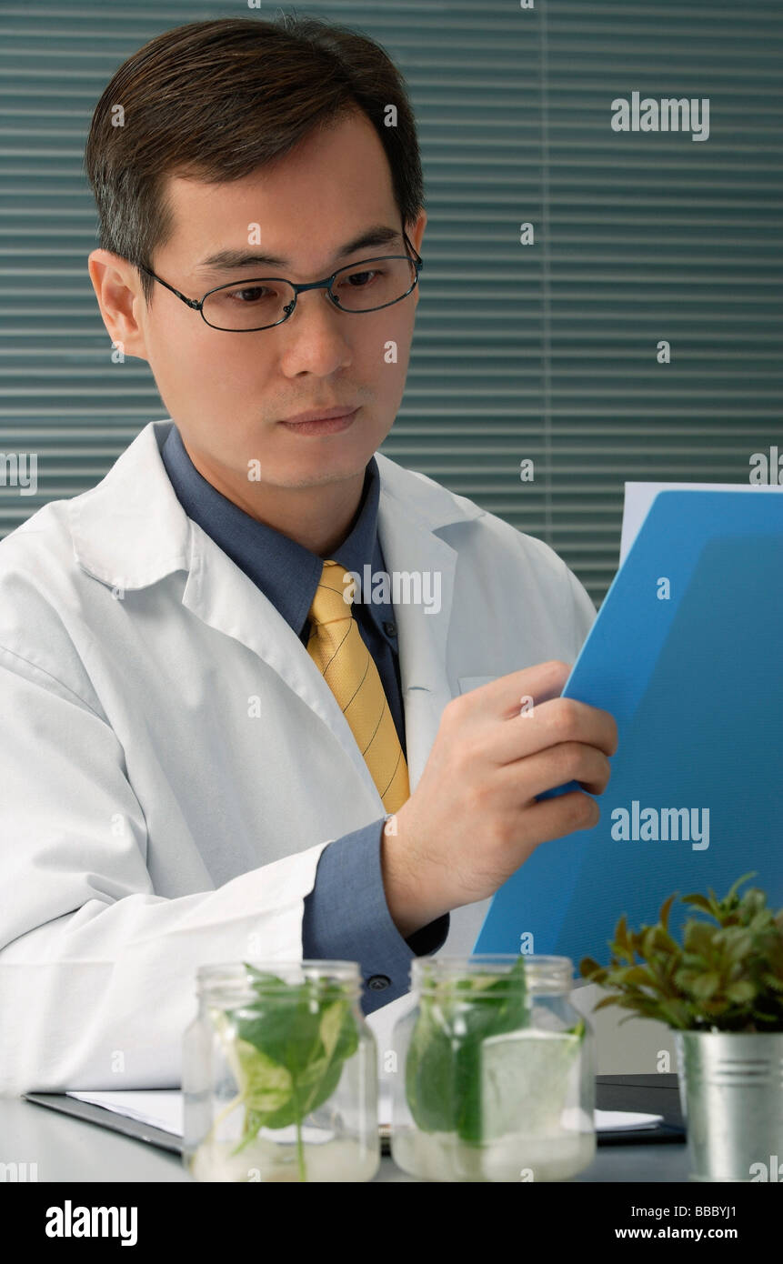 Scientist examining jar with plant samples Stock Photo