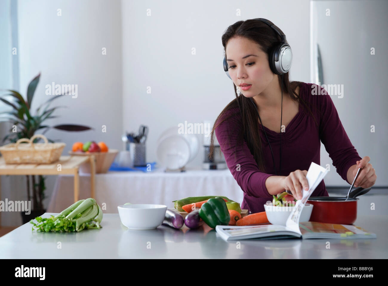 Young woman cooking while listening to music Stock Photo Alamy