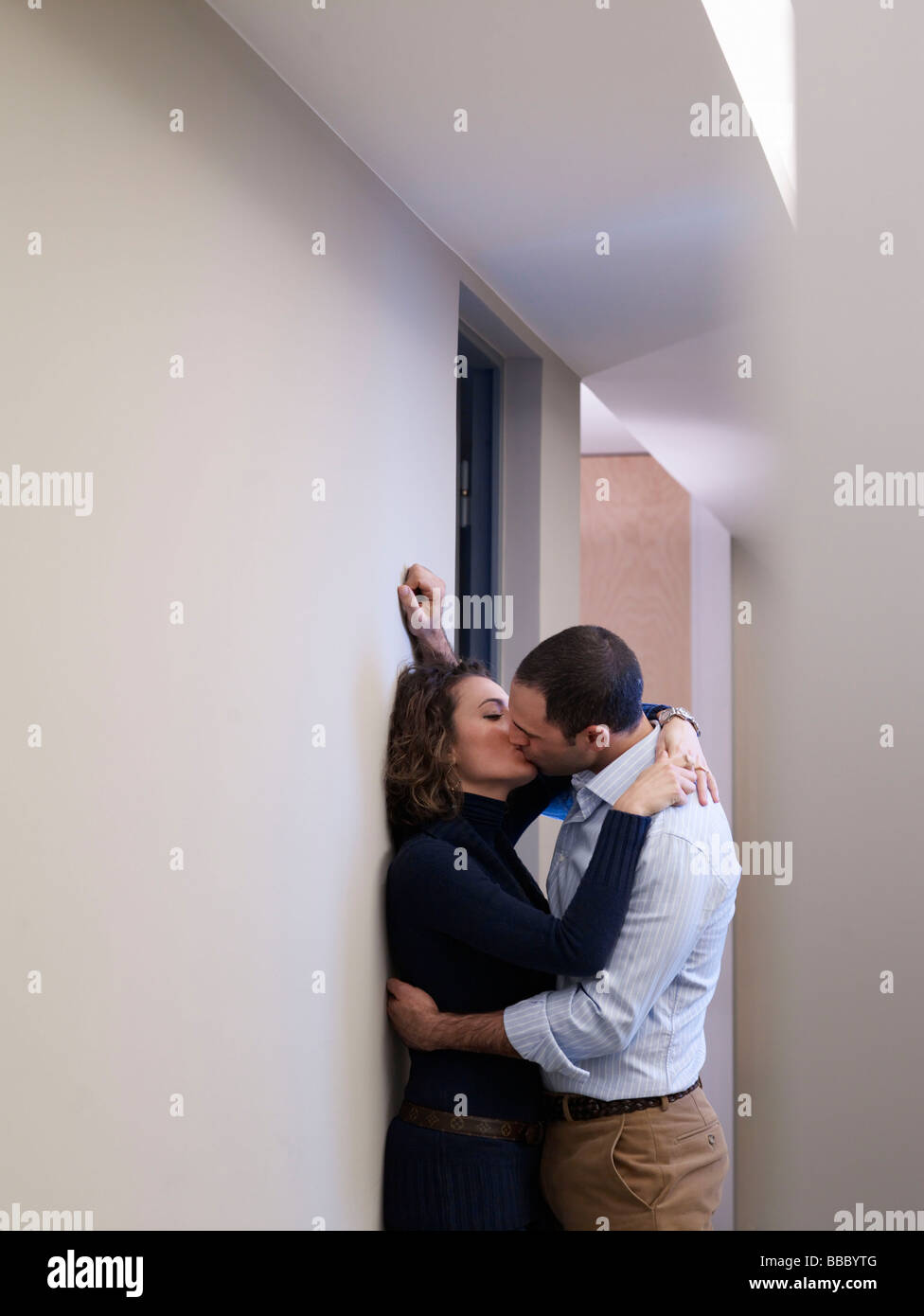 Couple kissing in an office corridor Stock Photo - Alamy