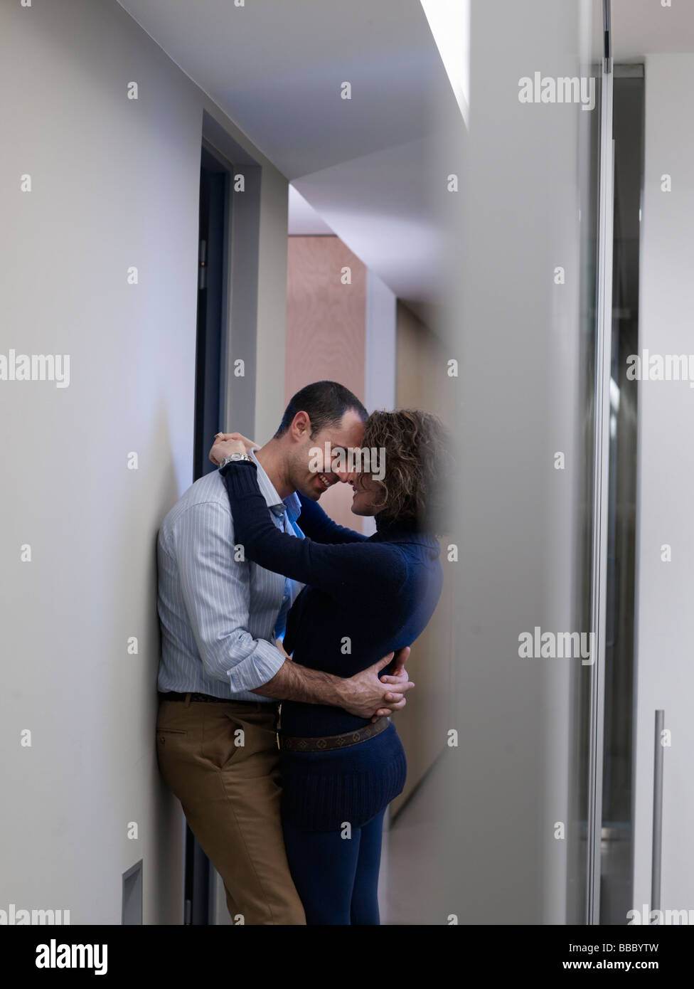 Couple kissing in an office corridor Stock Photo
