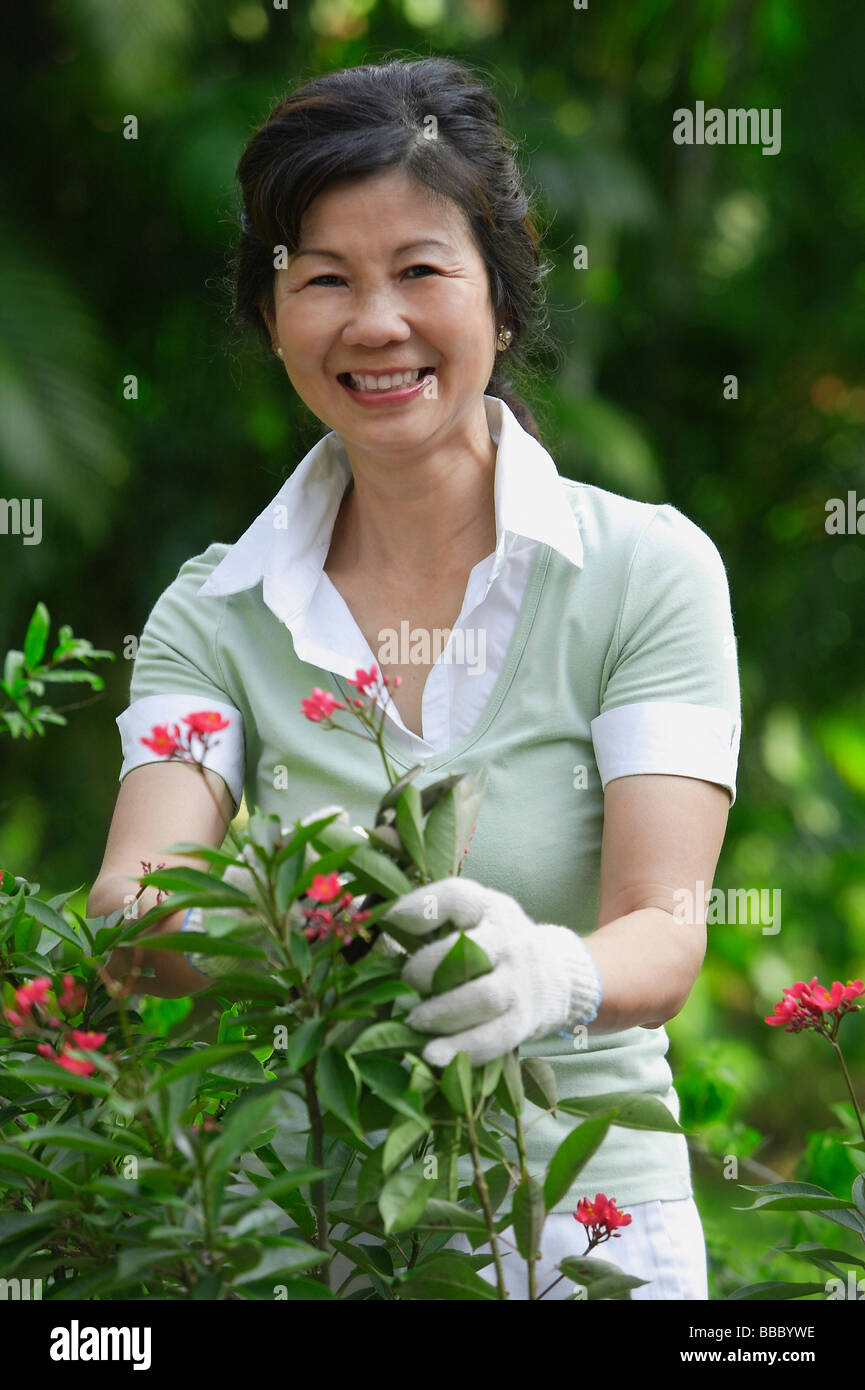 A woman pruning flowers in the garden Stock Photo