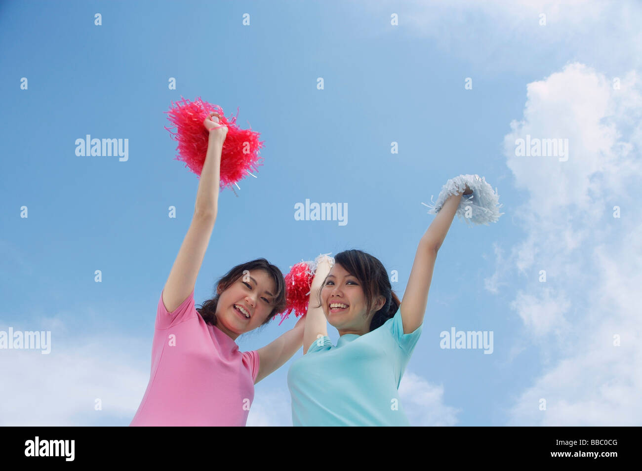 Young woman cheerleading with pom poms Stock Photo