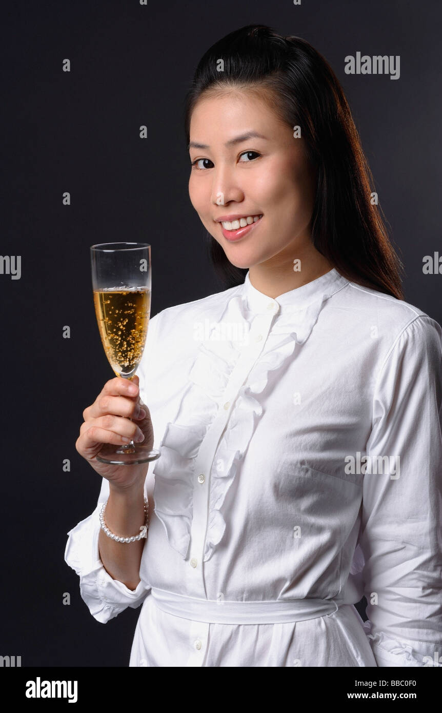 Young woman toasting with champagne and looking at camera Stock Photo