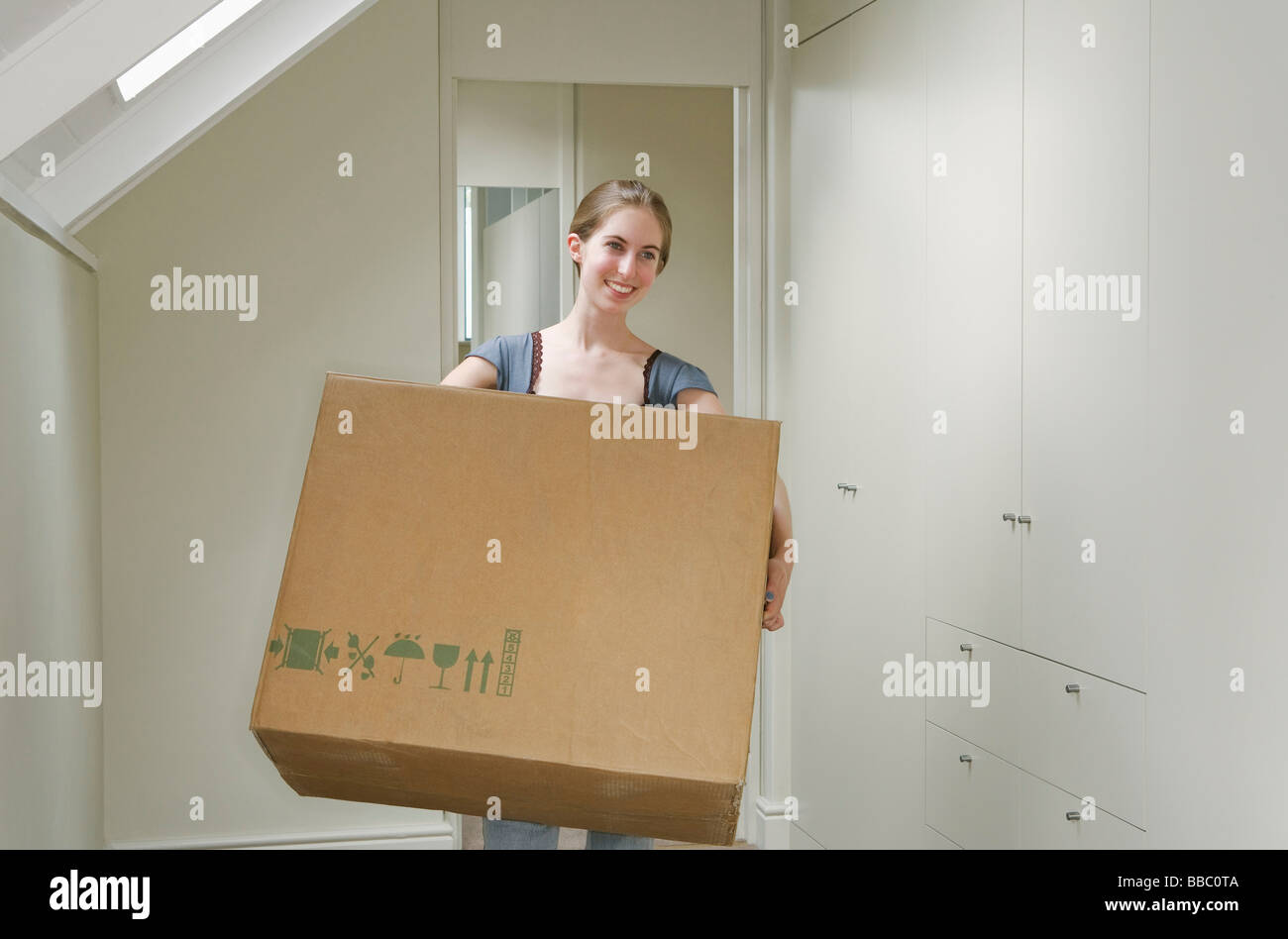 Woman carrying large box Stock Photo Alamy