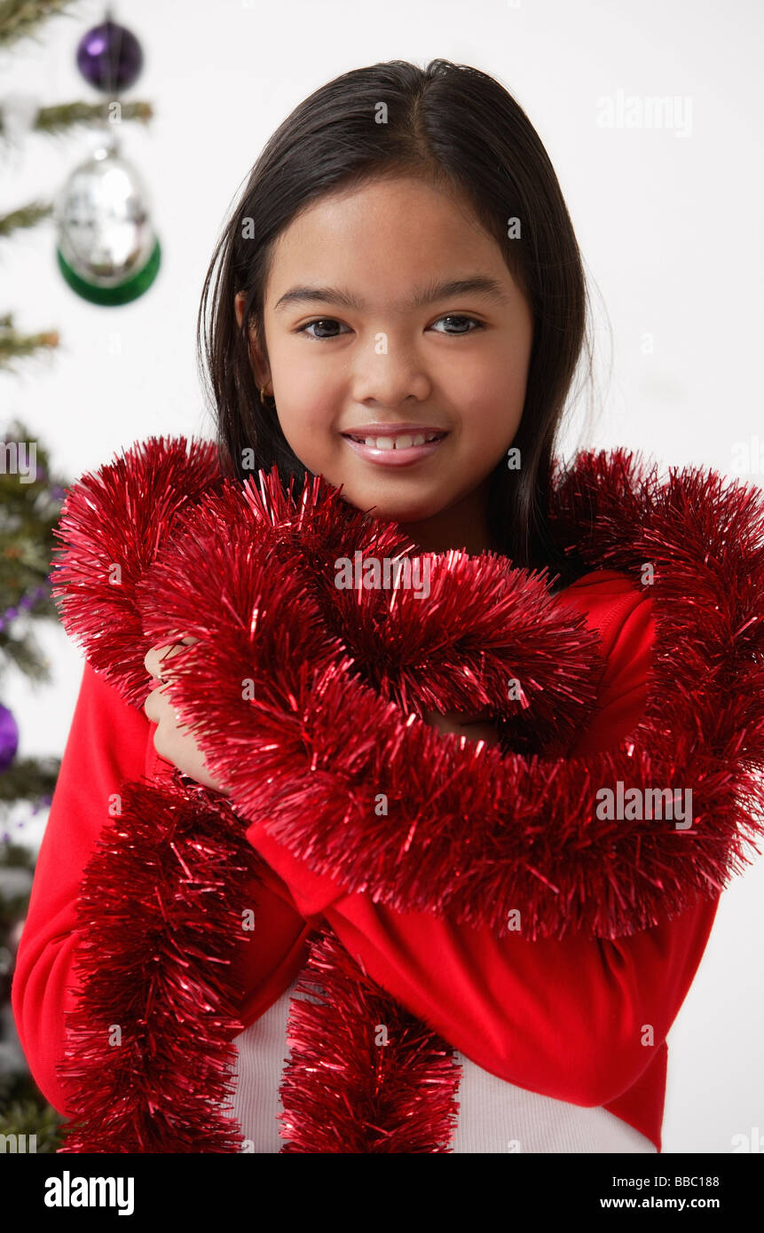 Girl with red tinsel wrap around neck shoulder Stock Photo