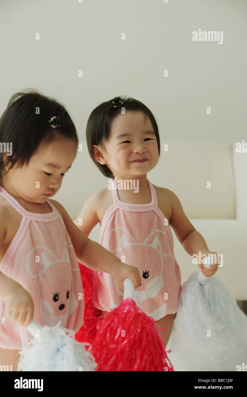 Baby girls with pom-poms Stock Photo
