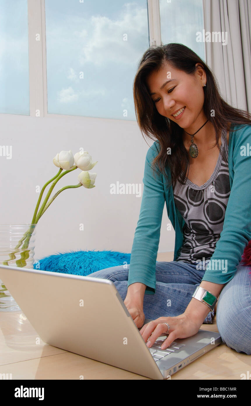 Woman sitting on floor using laptop Stock Photo - Alamy