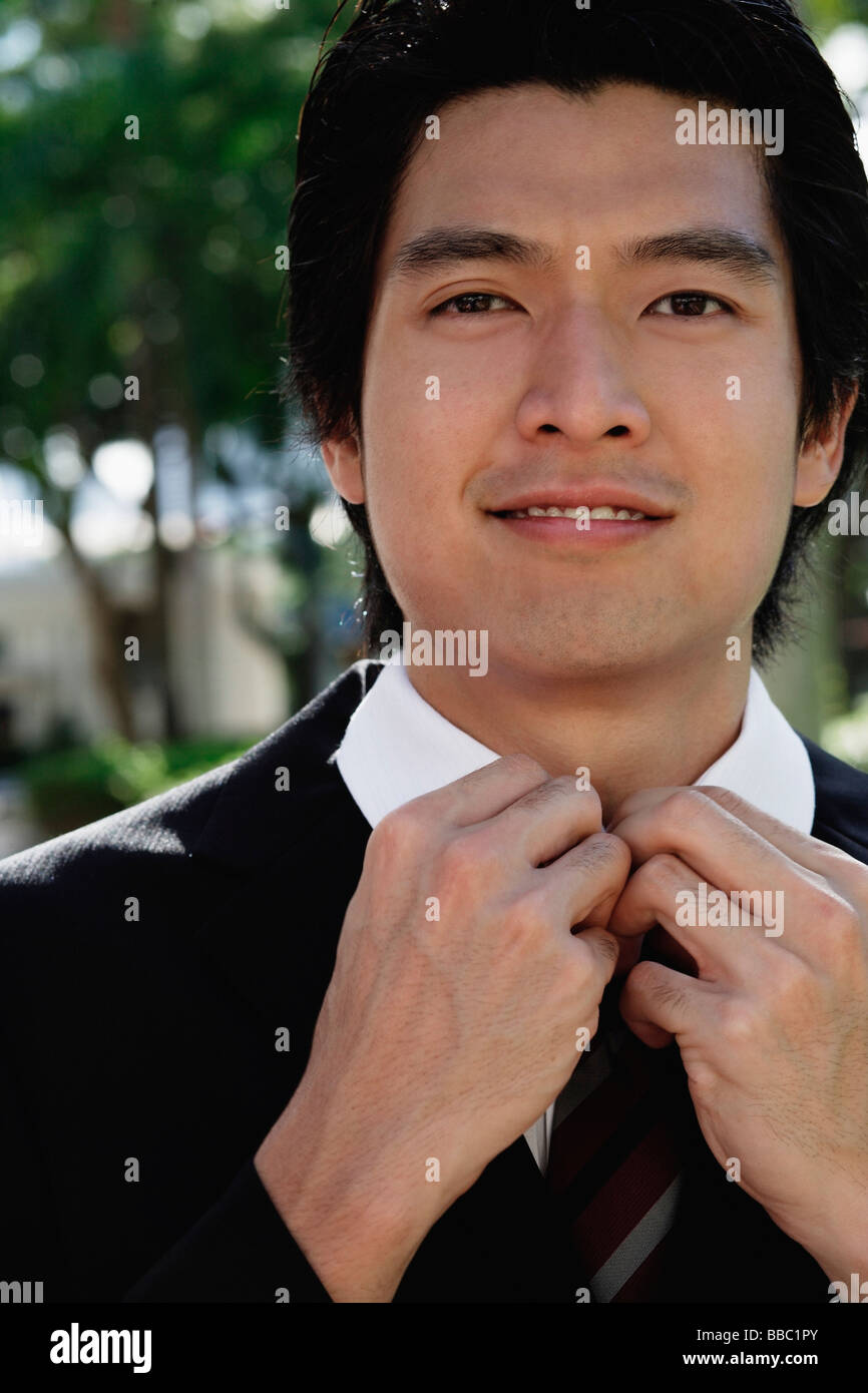 A man adjusts his tie Stock Photo - Alamy